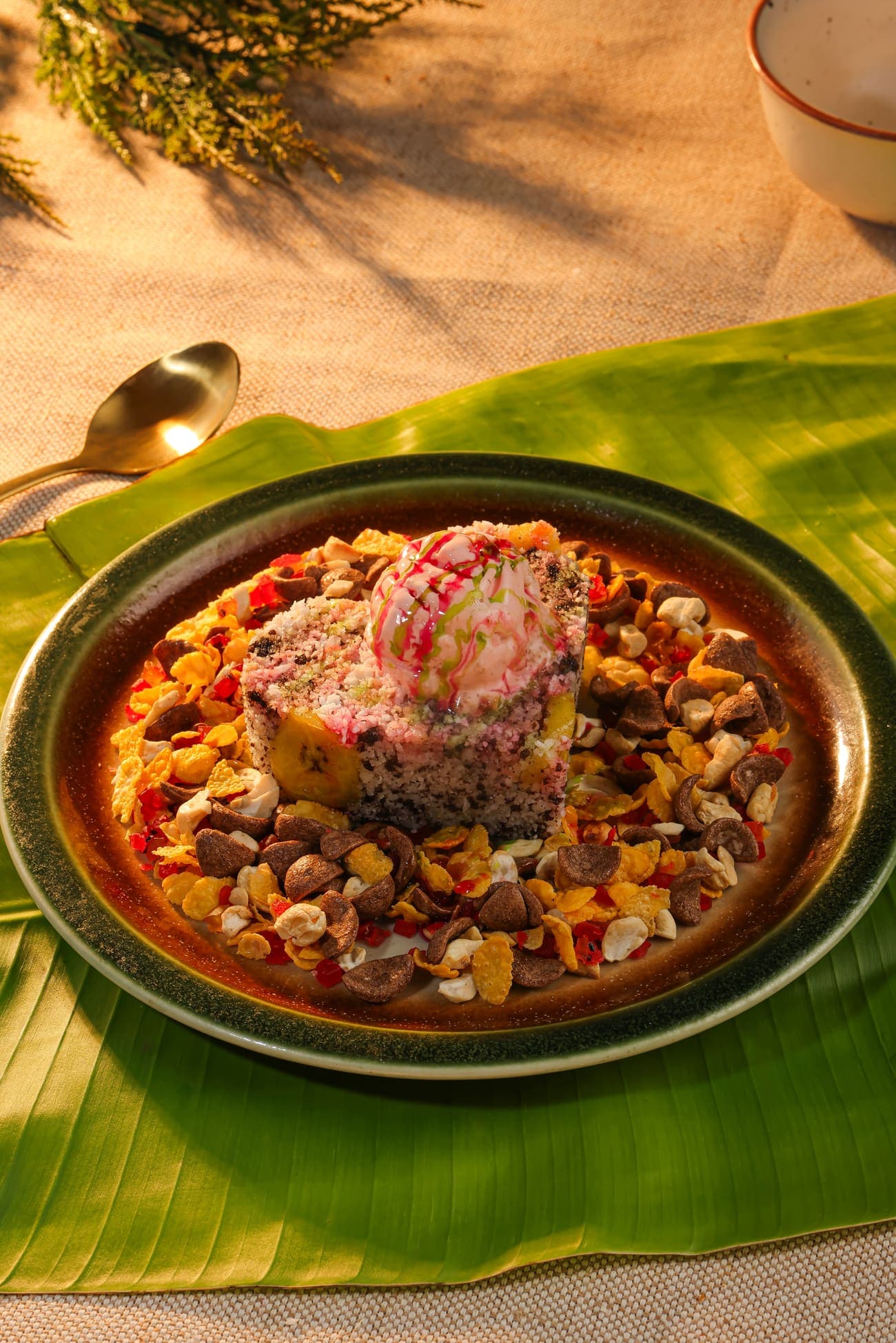 Celebration puttu crowned with ice cream on a plate of nuts, cornflakes and chocolate